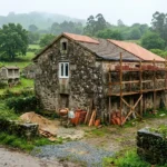 Casa de piedra gallega en rehabilitación con tejado nuevo y andamio